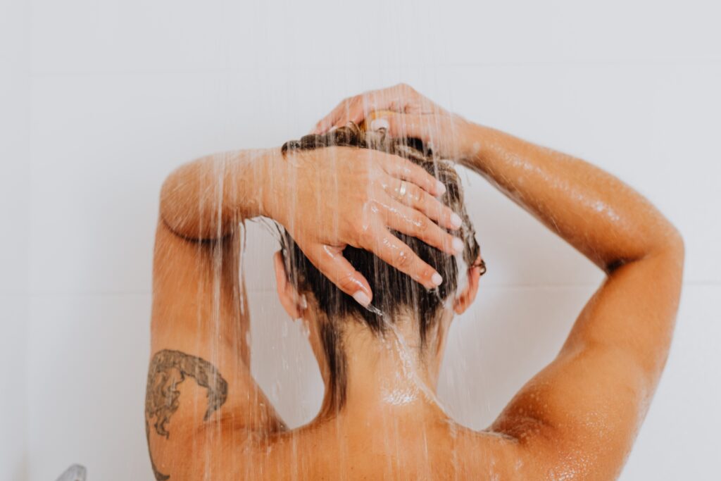 A woman showering with a new tattoo. 